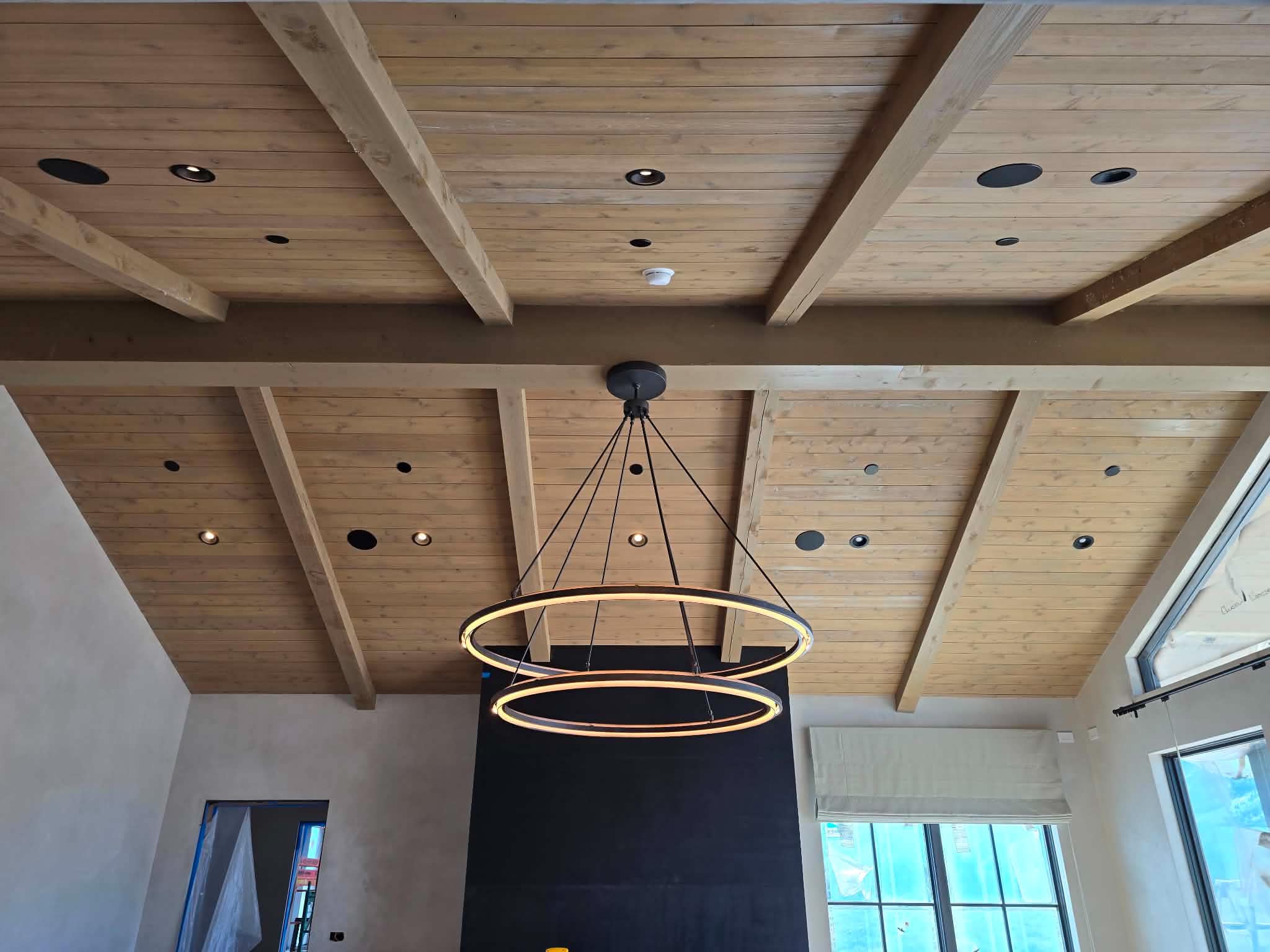 Double ring chandelier hung in a vaulted wood ceiling by Supreme Electric
